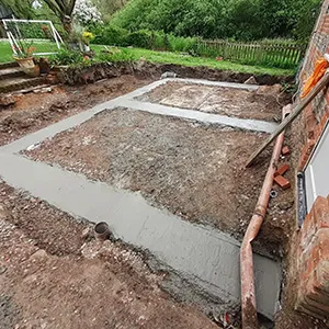 a house being built with concrete and a brick wall