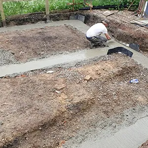 a man kneeling down on a cement slab