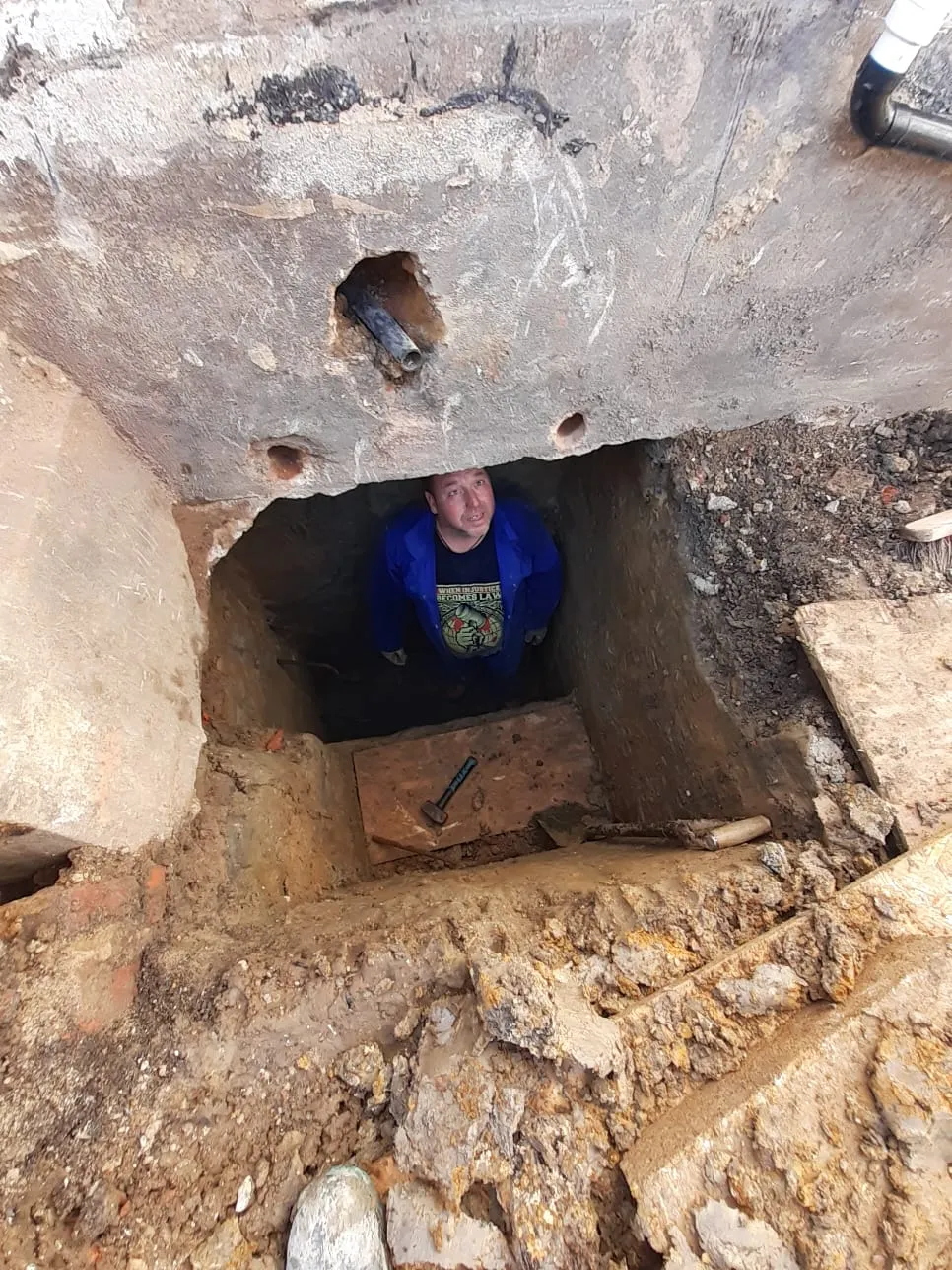 A man standing in a hole in the ground.