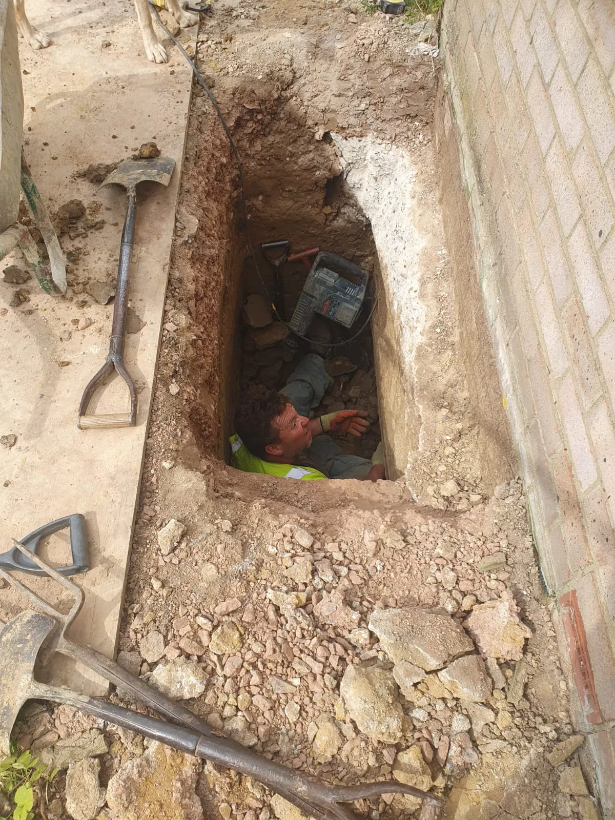 A man laying in a hole in the ground.