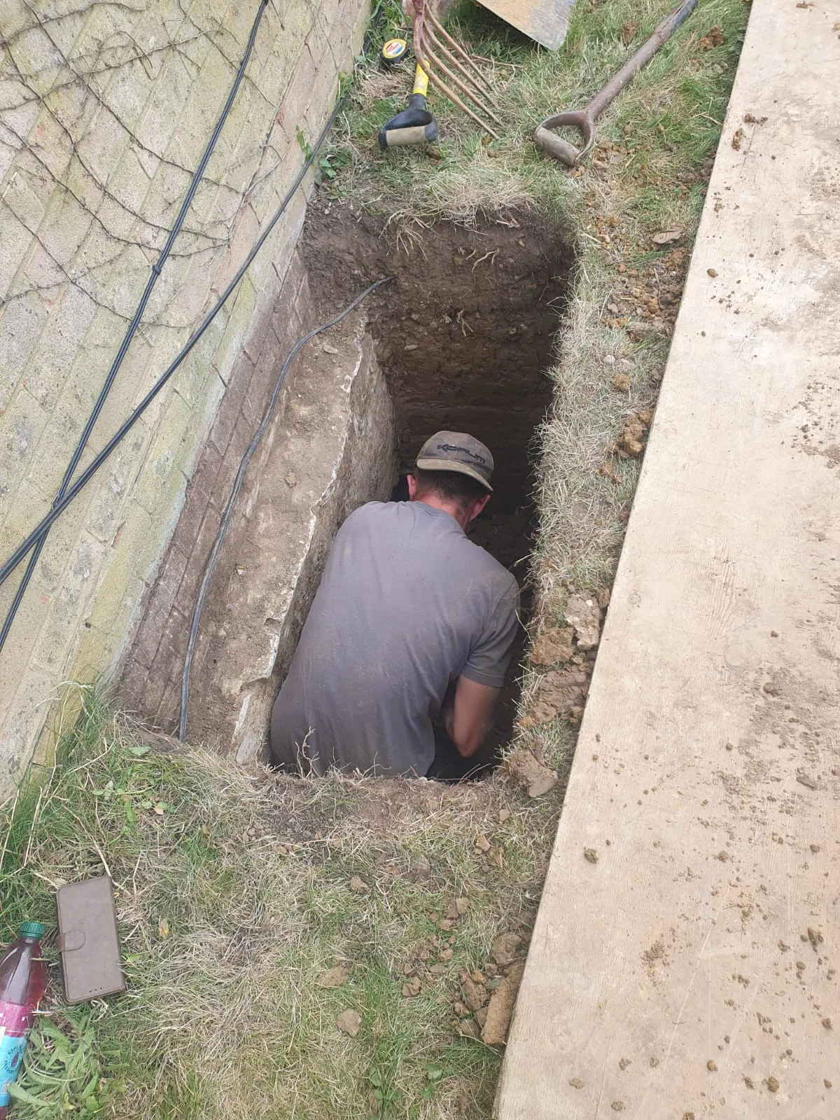 A man sitting in a hole in the ground.