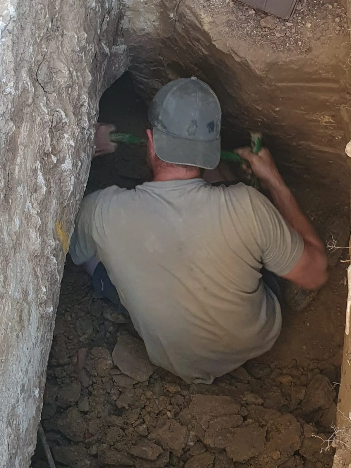 a man with a baseball cap is in a cave