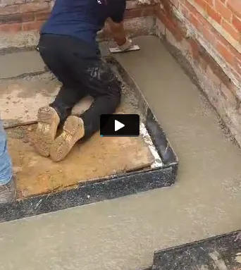 A man is laying concrete on the ground.