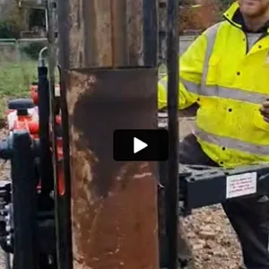 a man in a yellow jacket standing next to a machine