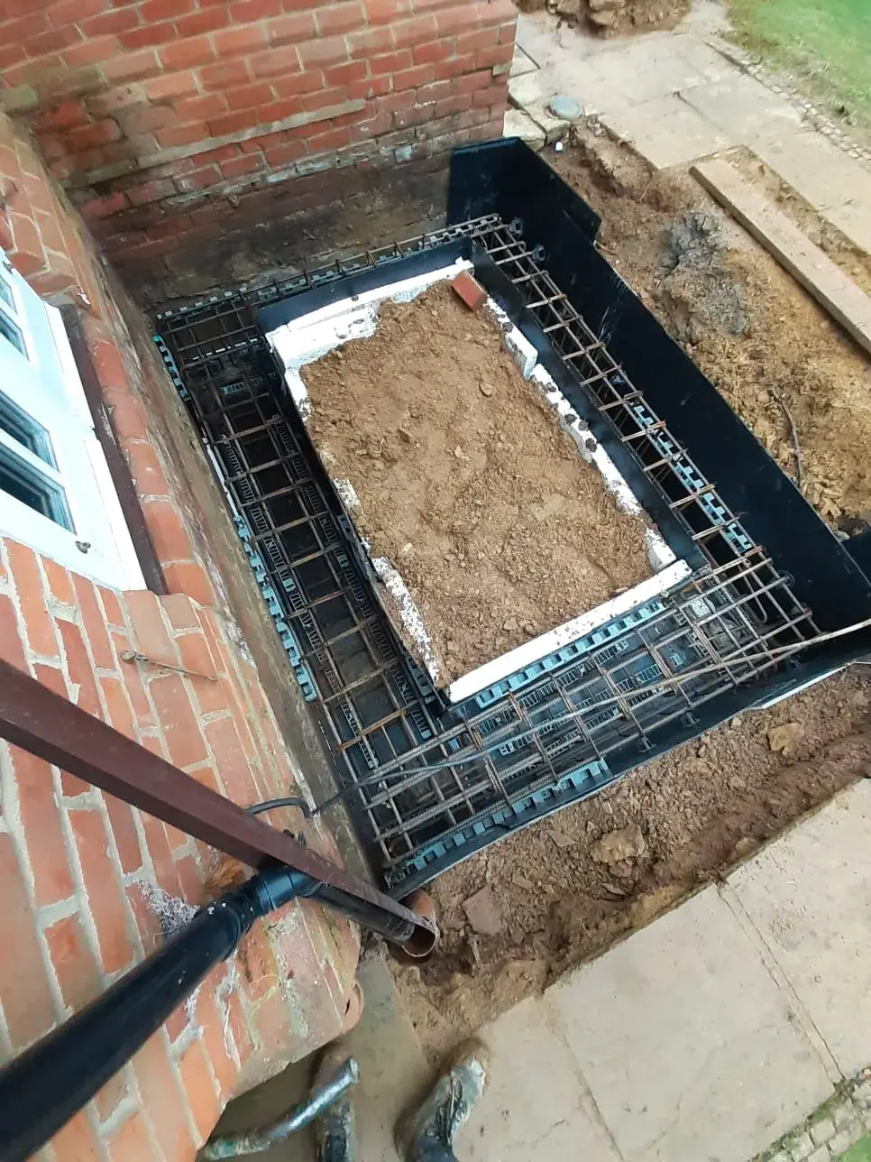 a brick wall with a metal grate in it