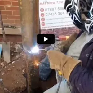 A man welding a piece of metal with a welder.