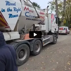 A man standing next to a truck on a street.