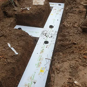 a white pipe laying on top of a dirt field