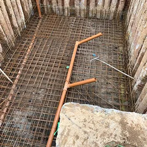 A construction site with a concrete floor and a wire fence.